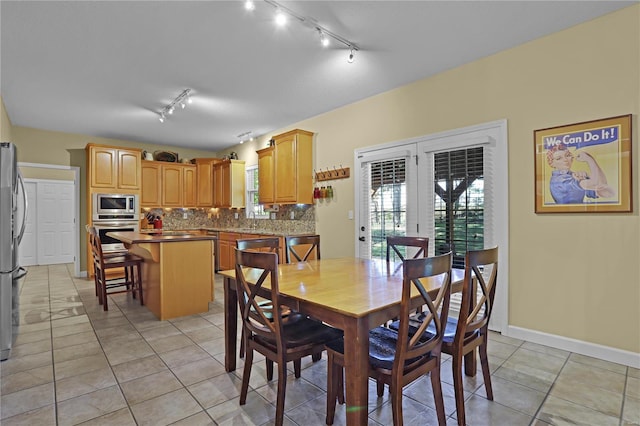 dining area featuring french doors, light tile patterned flooring, sink, and track lighting