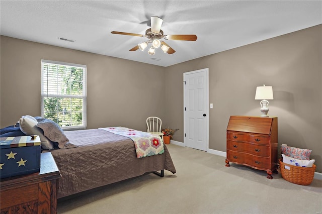 carpeted bedroom with ceiling fan and a textured ceiling