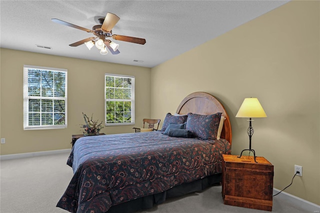 carpeted bedroom with a textured ceiling and ceiling fan