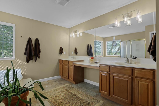 bathroom with tile patterned flooring, a shower with door, and vanity