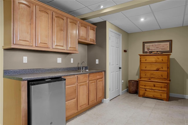 kitchen featuring stainless steel refrigerator, a paneled ceiling, and sink