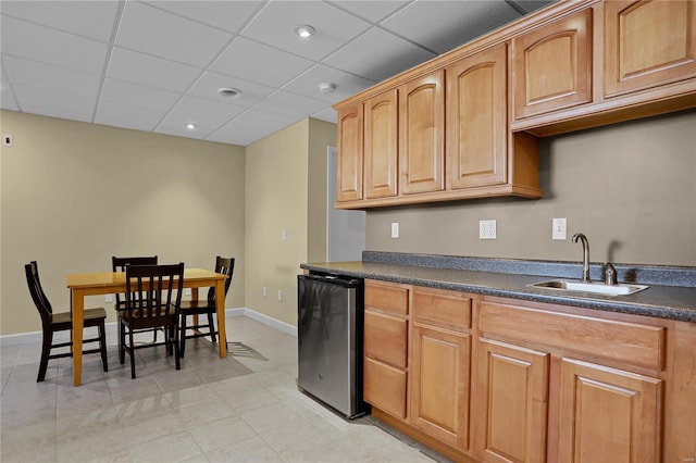 kitchen with stainless steel refrigerator, a paneled ceiling, sink, and light tile patterned flooring