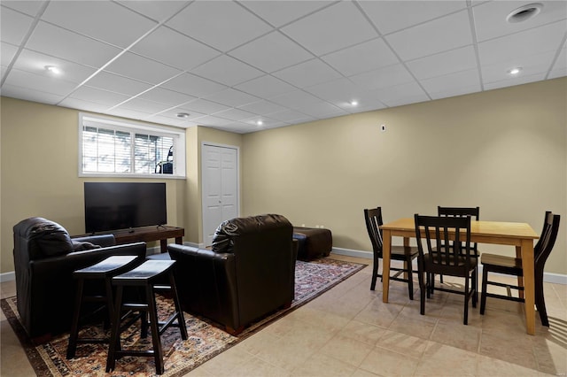 tiled living room featuring a drop ceiling