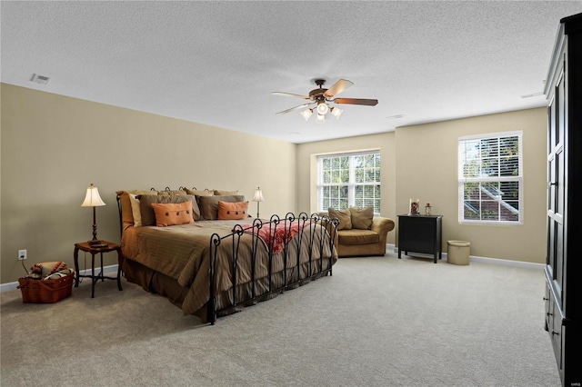 bedroom featuring multiple windows, light carpet, and ceiling fan