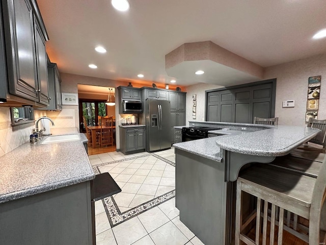 kitchen with sink, kitchen peninsula, gray cabinetry, appliances with stainless steel finishes, and light tile patterned floors