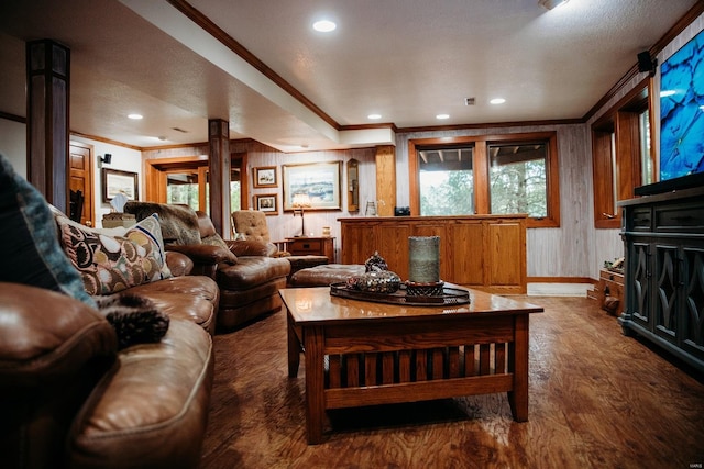 living room with a textured ceiling, crown molding, wood walls, and dark hardwood / wood-style floors