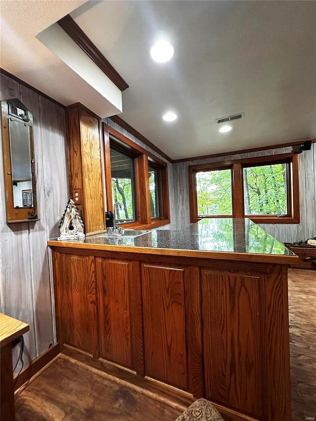 kitchen with kitchen peninsula, dark wood-type flooring, and sink