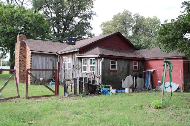 rear view of house featuring a lawn