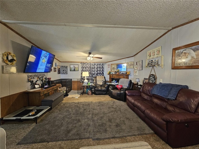 living room with vaulted ceiling, a textured ceiling, ceiling fan, carpet, and ornamental molding