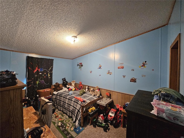 carpeted bedroom with ornamental molding, a textured ceiling, and vaulted ceiling