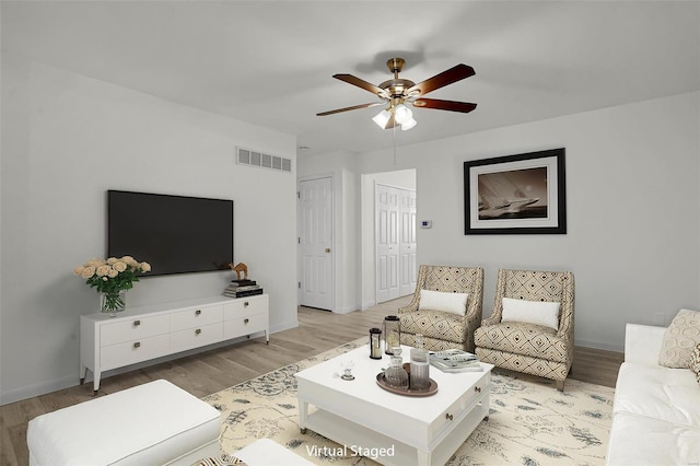 living room featuring ceiling fan and light hardwood / wood-style flooring