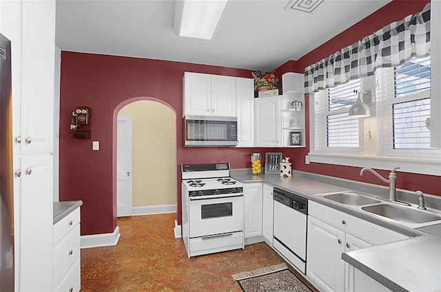 kitchen featuring white appliances, sink, and white cabinets