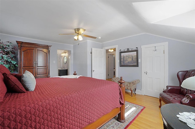 bedroom featuring light wood-type flooring, ceiling fan, crown molding, vaulted ceiling, and ensuite bathroom