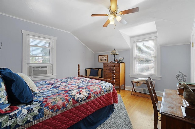 bedroom with ceiling fan, cooling unit, light hardwood / wood-style floors, crown molding, and vaulted ceiling