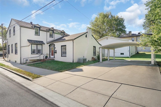 view of front of house with a front lawn, a carport, and central AC unit