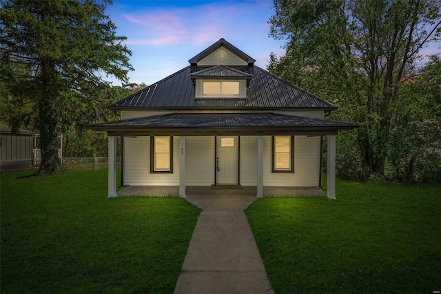 view of front of property with a porch and a lawn