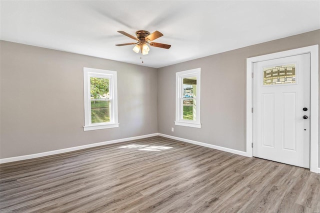 foyer entrance with ceiling fan and light wood-type flooring