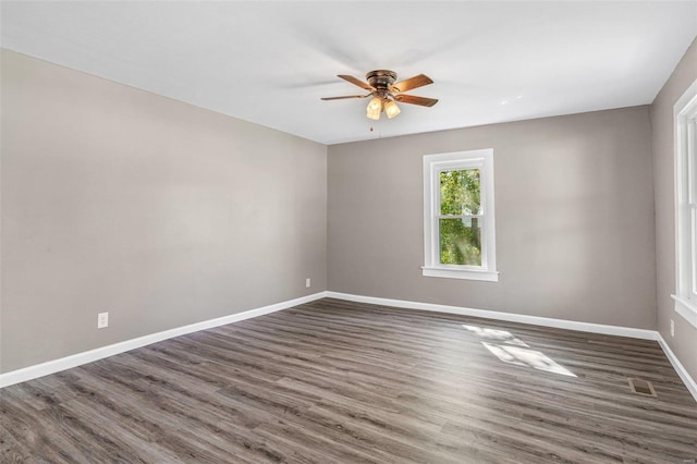 empty room featuring dark hardwood / wood-style flooring and ceiling fan