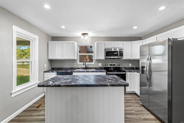 kitchen with stainless steel appliances, sink, dark hardwood / wood-style flooring, and a center island