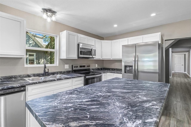 kitchen with dark hardwood / wood-style flooring, white cabinets, appliances with stainless steel finishes, and sink