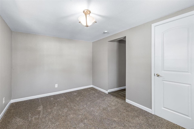 unfurnished room with dark carpet