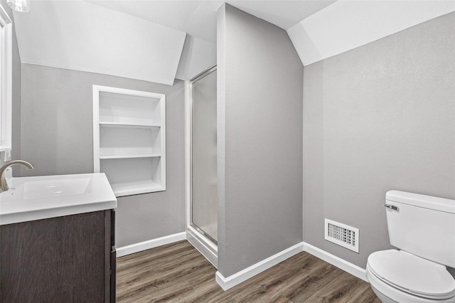 bathroom featuring walk in shower, vaulted ceiling, toilet, and hardwood / wood-style floors