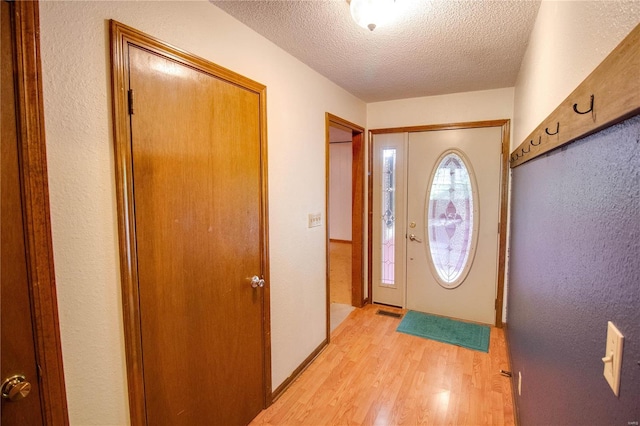 entryway featuring a textured ceiling and light hardwood / wood-style floors