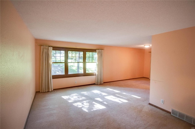 carpeted spare room with a textured ceiling