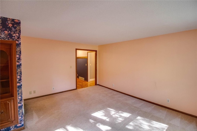 carpeted empty room featuring a textured ceiling