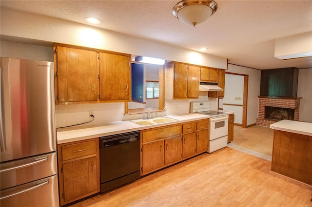 kitchen featuring stove, stainless steel fridge, sink, dishwasher, and light wood-type flooring