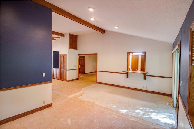 empty room with lofted ceiling with beams