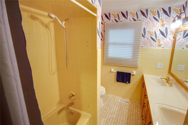 full bathroom featuring vanity, shower / bath combo, a textured ceiling, tile walls, and toilet