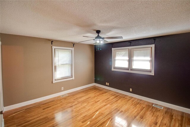 empty room with wood-type flooring, a textured ceiling, and ceiling fan