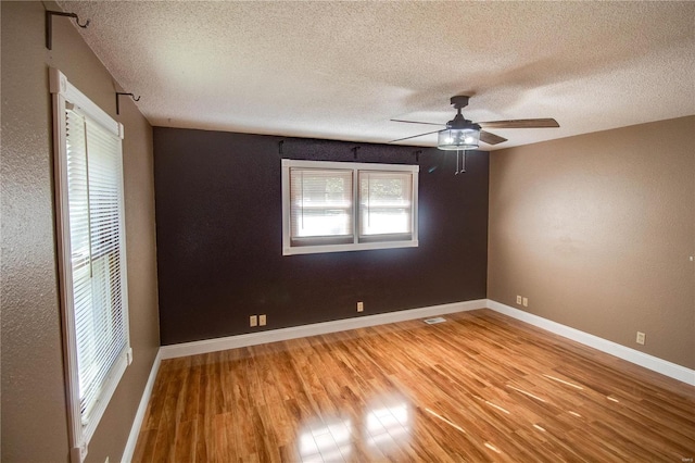 unfurnished room featuring a textured ceiling, light hardwood / wood-style floors, and ceiling fan