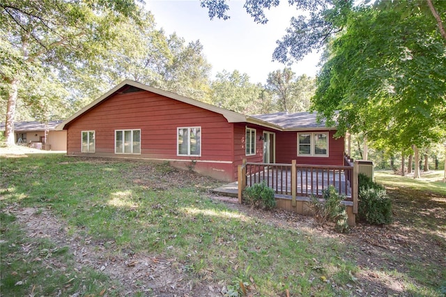 exterior space featuring a wooden deck and a lawn