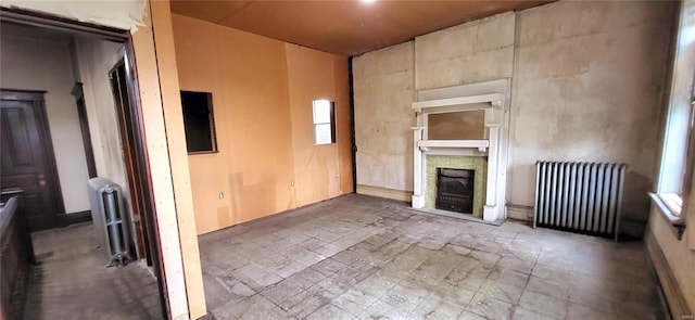 unfurnished living room with radiator and a fireplace