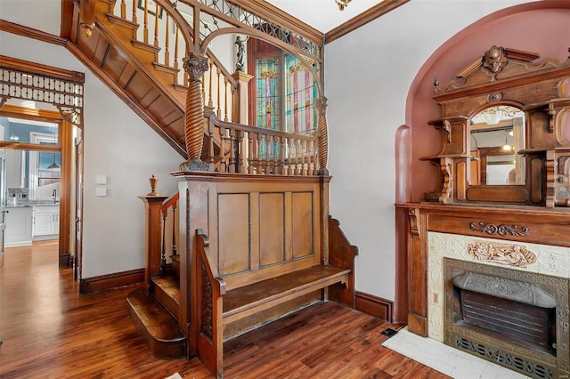 staircase featuring hardwood / wood-style floors, crown molding, and sink