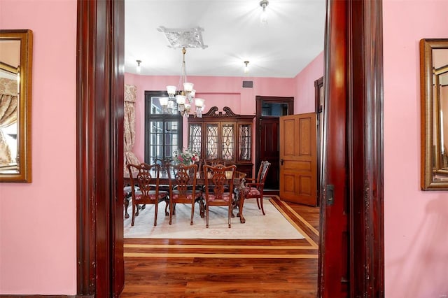 dining room featuring hardwood / wood-style flooring and a notable chandelier