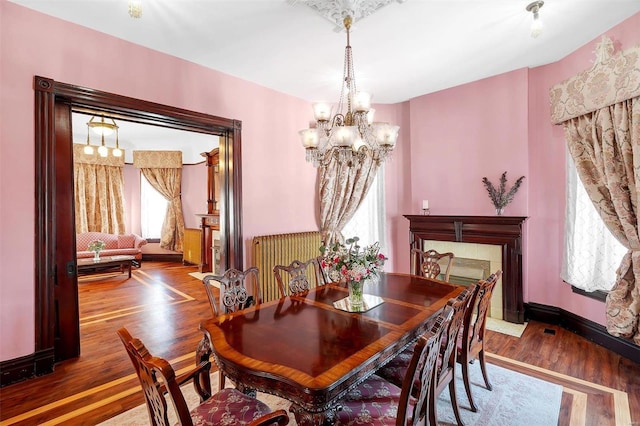 dining room with hardwood / wood-style floors and an inviting chandelier