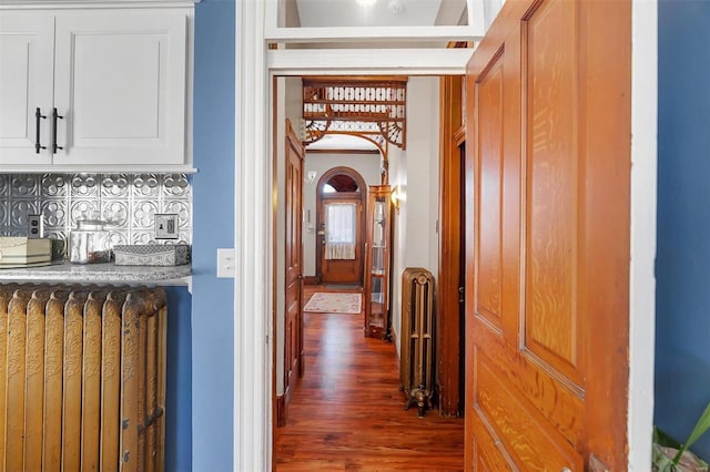 corridor with dark hardwood / wood-style floors and radiator