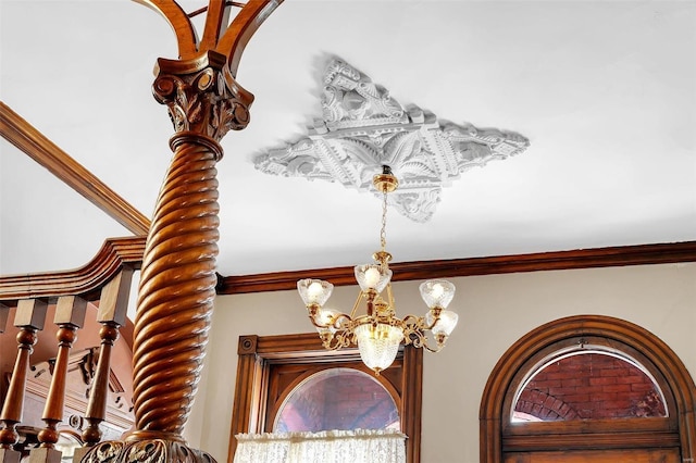 interior details featuring a notable chandelier and crown molding