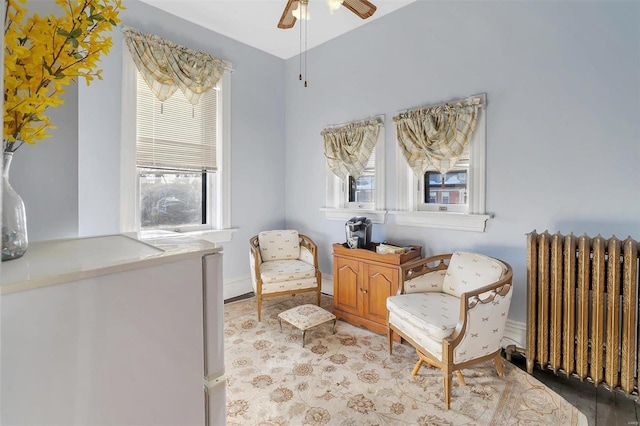 living area featuring radiator and ceiling fan