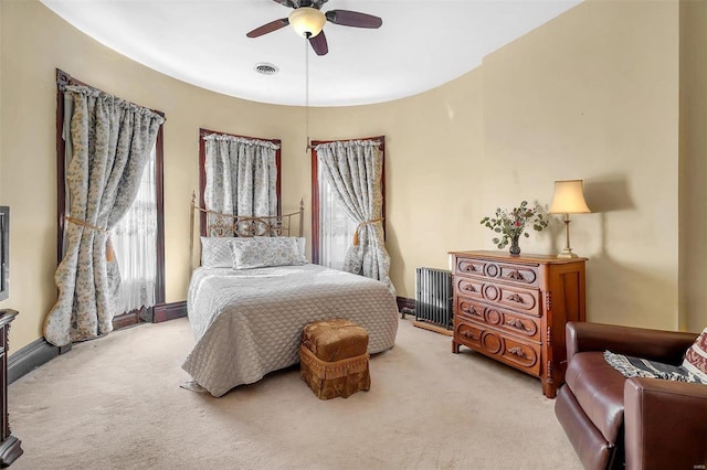 carpeted bedroom featuring multiple windows and ceiling fan