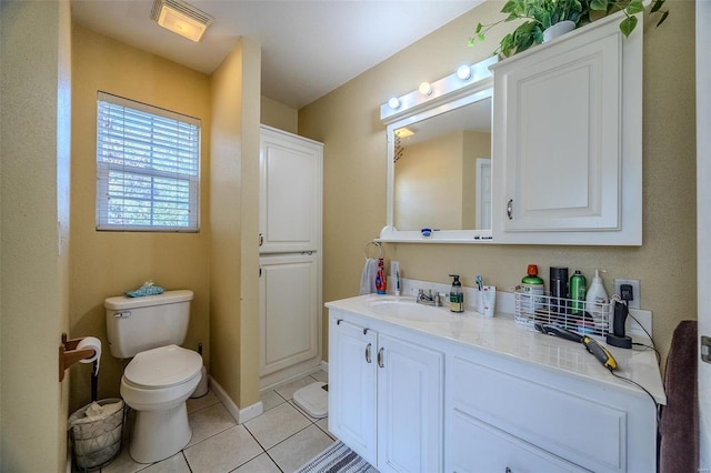 bathroom with tile patterned flooring, vanity, and toilet