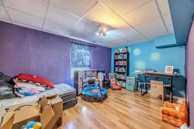 bedroom featuring a drop ceiling and hardwood / wood-style floors