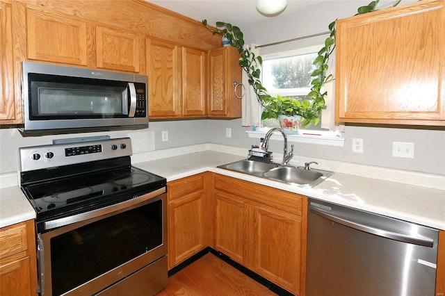 kitchen featuring appliances with stainless steel finishes, light hardwood / wood-style floors, and sink