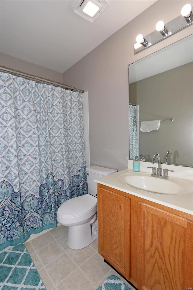 bathroom with a shower with shower curtain, tile patterned flooring, vanity, and toilet