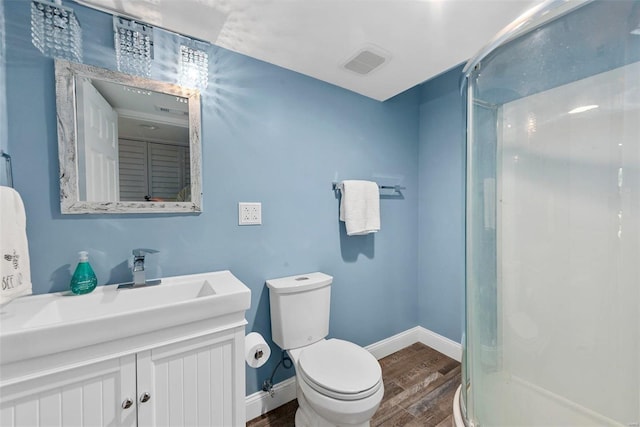 bathroom featuring toilet, walk in shower, vanity, and wood-type flooring