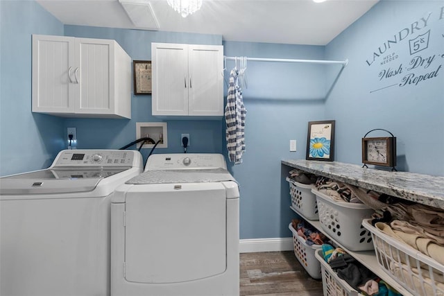 laundry area featuring cabinets, dark hardwood / wood-style floors, and washer and clothes dryer