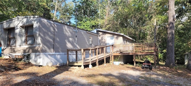 rear view of house featuring a wooden deck